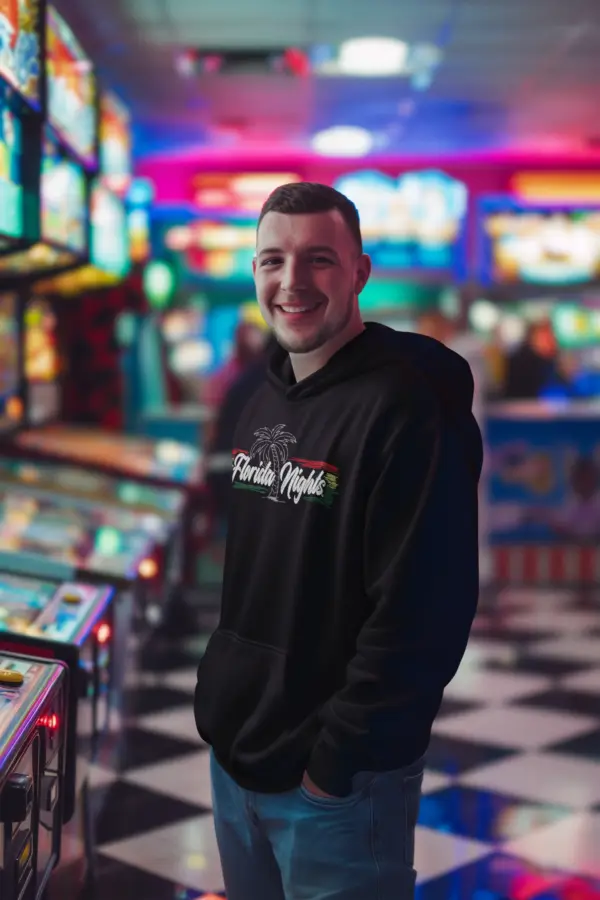 Man wearing a black fleece hoodie with rasta-inspired embroidered lettering, styled casually to highlight its luxurious look and comfortable fit, available in sizes S-3XL.