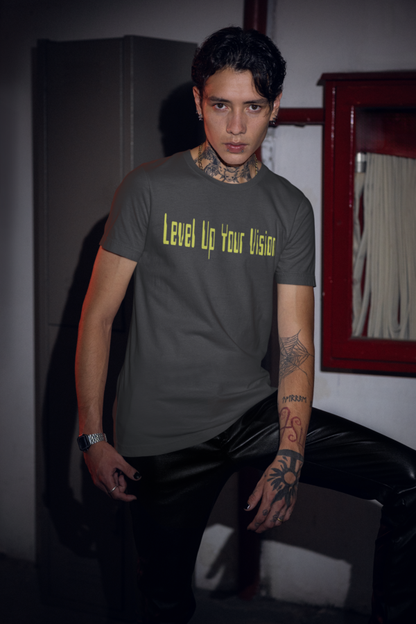 Model wearing a gray triblend t-shirt with the Level Up Your Vision; motivational design, styled casually to highlight its luxurious look and comfortable fit, available in sizes S-3XL.