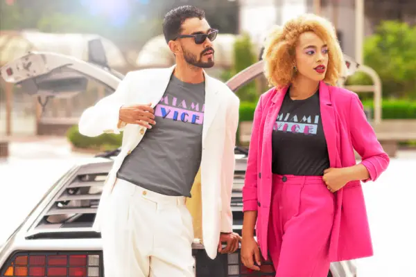 Man and woman in suits wearing a gray/pink/blue and black/blue/pink triblend t-shirts