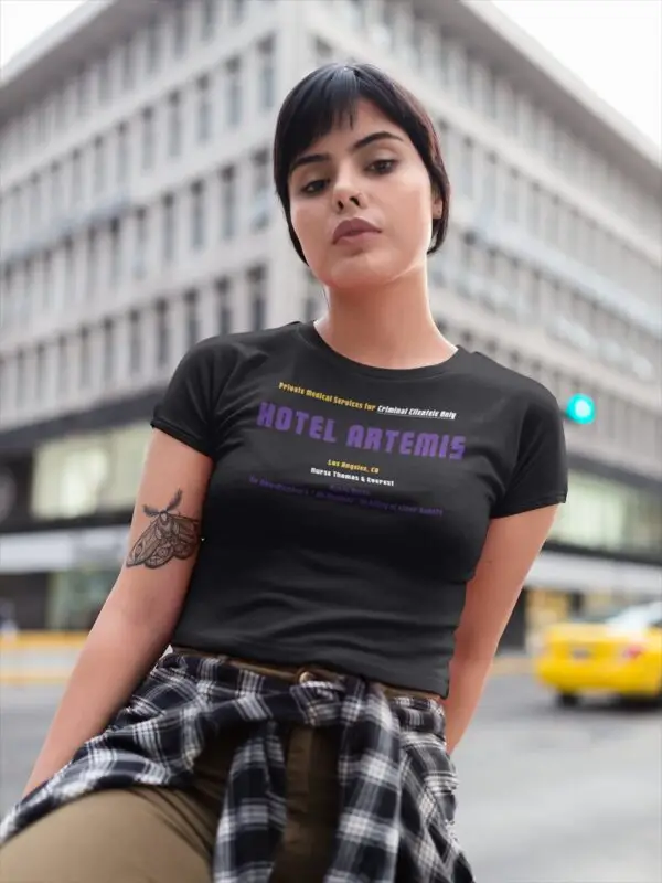 Homepage - Young lady wearing a black Hotel Artemis t-shirt